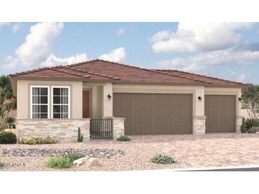 Tan three-car garage home with a terracotta tile roof and stone accents at 18225 W Hess St, Goodyear, AZ 85338