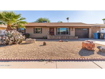 Ranch style home with desert landscaping and a two-car garage at 2407 W Laurel Ln, Phoenix, AZ 85029