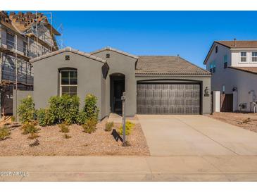 Modern single-story home with gray exterior, two-car garage, and landscaping at 3238 W Garnet St, San Tan Valley, AZ 85144