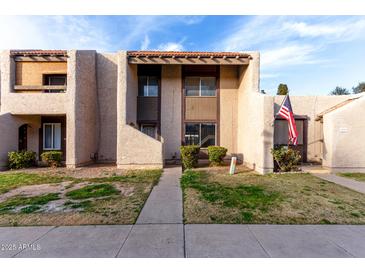 Two-story stucco townhome with a walkway and grassy area at 4303 W Solano N Dr, Glendale, AZ 85301