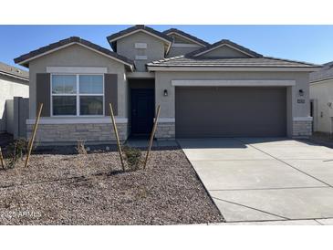 Single-story home with two-car garage and desert landscaping at 4929 S 105Th Ln, Tolleson, AZ 85353