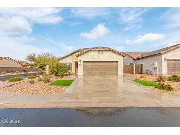 Single-story house with a two-car garage and desert landscaping at 5590 W Victory Way, Florence, AZ 85132