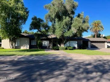 Ranch style home with mature landscaping and a two-car garage at 1144 W Edgemont Ave, Phoenix, AZ 85007