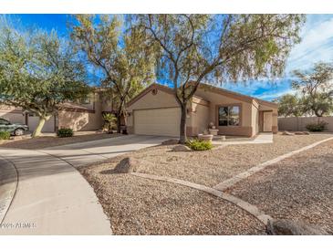 Single-story house with a two-car garage and desert landscaping at 11921 W Port Royale Ln, El Mirage, AZ 85335