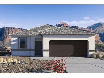 Single-story home with a two-car garage and desert landscaping at 1714 W Spaulding Ave, Apache Junction, AZ 85120