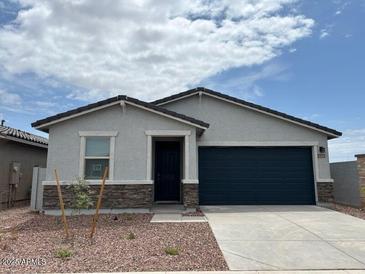 Charming single-story home featuring stone accents, a two-car garage, and desert landscaping at 17457 W Eva St, Waddell, AZ 85355