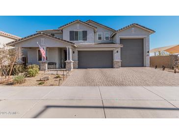 Two-story home with gray exterior, three-car garage, and landscaped front yard at 25509 N 140Th Dr, Surprise, AZ 85387