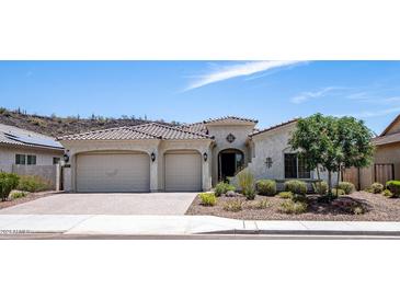 Single-story home with two-car garage,landscaped yard, and mountain views at 30401 N 115Th Dr, Peoria, AZ 85383