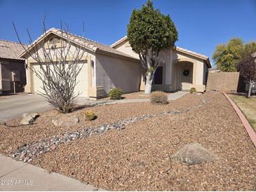 Charming single-story home with desert landscaping, cozy front porch, and attached two-car garage at 3560 W Tina Ln, Glendale, AZ 85310