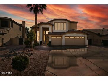 Two-story house with three-car garage, desert landscaping, and a palm tree in the front yard at 517 N Cambridge St, Gilbert, AZ 85233