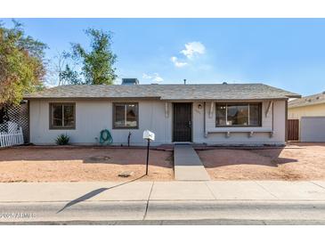 Ranch style home with a landscaped yard and a walkway to the front door at 5321 W Country Gables Dr, Glendale, AZ 85306