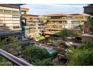 Aerial view of a community with lush landscaping, a pool, and modern building architecture at 7137 E Rancho Vista Dr # 6010, Scottsdale, AZ 85251