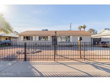 Ranch style home with a well-maintained front yard and a metal fence at 7501 E Pierce St, Scottsdale, AZ 85257