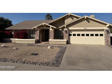 Single-story home with a two-car garage and desert landscaping at 8862 E Sheena Dr, Scottsdale, AZ 85260