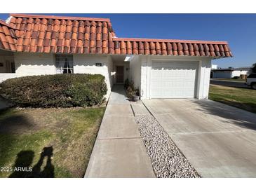 White single story home with tile roof, attached garage, and walkway at 10602 W Deanne Dr, Sun City, AZ 85351