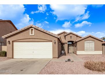 One-story home with a two-car garage and desert landscaping at 13450 W Maui Ln, Surprise, AZ 85379