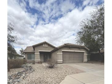 Charming single-story home featuring desert landscaping, neutral paint, and a two-car garage at 13622 W Peck Ct, Litchfield Park, AZ 85340