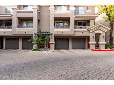 Building exterior featuring multiple units with attached garages and a well-maintained courtyard at 4455 E Paradise Village S Pkwy # 1031, Phoenix, AZ 85032