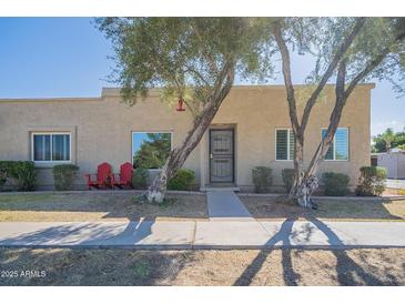 Tan stucco house with red chairs and mature trees in front at 5120 N 81St St, Scottsdale, AZ 85250