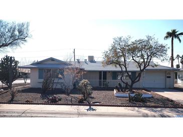 Ranch style home with mature landscaping and a spacious front yard at 11001 W Connecticut Ave, Sun City, AZ 85351