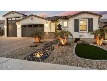 Charming single-story home featuring professional desert landscaping, stone accents, and a three-car garage at 12528 W Tuckey Ln, Glendale, AZ 85307