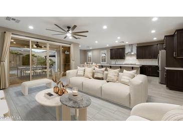 Bright living room featuring neutral tones, a large sofa, and seamless flow to the outdoor dining area at 12528 W Tuckey Ln, Glendale, AZ 85307