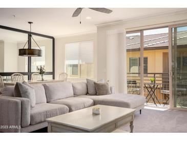 Bright living room featuring a comfortable sectional sofa, ceiling fan, and sliding glass doors to the balcony at 17850 N 68Th St # 3120, Phoenix, AZ 85054