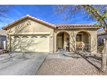 Tan house with arched entryway, two-car garage, and desert landscaping at 2524 W Saint Catherine Ave, Phoenix, AZ 85041