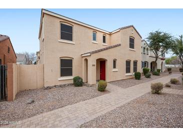 Charming two-story stucco home featuring a red door, tidy landscaping, and a paved walkway at 2646 E Megan St, Gilbert, AZ 85295