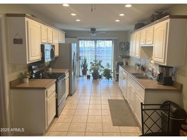 Bright kitchen with ample cabinetry, stainless steel appliances, and tile flooring at 455 S Delaware Dr # 117, Apache Junction, AZ 85120