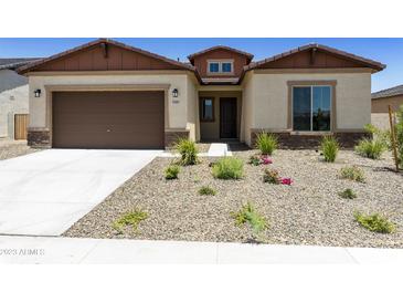 One-story home with brown garage door and landscaped front yard at 5509 N 193Rd Ave, Litchfield Park, AZ 85340