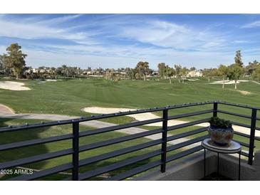 Scenic golf course view from the balcony features lush greens and sand traps under a partly cloudy blue sky at 7400 E Gainey Club Dr # 222, Scottsdale, AZ 85258