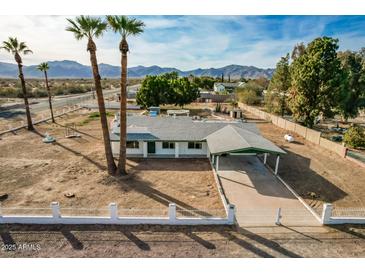 Aerial view of a single-story home with a large yard and mountain views at 13802 N 183Rd Ave, Surprise, AZ 85388