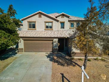 Two-story house with brown garage door and neutral exterior at 15058 W Fillmore St, Goodyear, AZ 85338