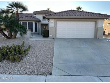 One-story house with tile roof, two-car garage, and desert landscaping at 18256 N Villa Bella Dr, Surprise, AZ 85374