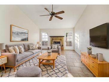 Living room with tiled floors, fireplace and neutral decor at 4648 W Continental Dr, Glendale, AZ 85308