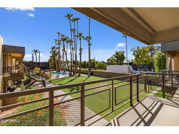 View from patio shows pool, grassy area, and palm trees at 6501 N 17Th Ave # 112, Phoenix, AZ 85015