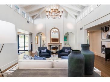 Spacious living room with high ceilings, chandelier, and fireplace at 7500 E Mccormick Pkwy # 32, Scottsdale, AZ 85258