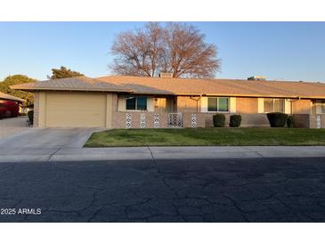 Brick ranch home with attached garage and well-manicured lawn at 10604 W Camelot Cir, Sun City, AZ 85351