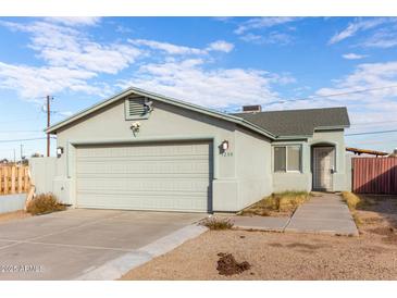 Single-story house with a two-car garage and landscaped yard at 1208 E Hess Ave, Phoenix, AZ 85034