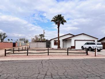 Single-story home with a well-maintained front yard and split-rail fence at 1302 E 30Th Ave, Apache Junction, AZ 85119