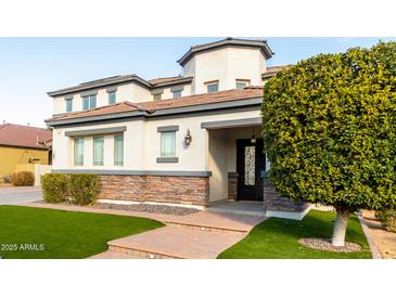 Two-story house with stone accents and landscaped lawn at 15446 W Montecito Ave, Goodyear, AZ 85395