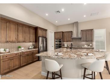 Modern kitchen featuring a spacious island, stainless steel appliances, and custom wood cabinets at 16639 W Pinchot Ave, Goodyear, AZ 85395