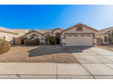 One-story house with beige exterior, two-car garage, and landscaped front yard at 19045 N 47Th Cir, Glendale, AZ 85308