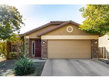 Tan house with a two-car garage and stone accents at 2731 W Wayland Dr, Phoenix, AZ 85041