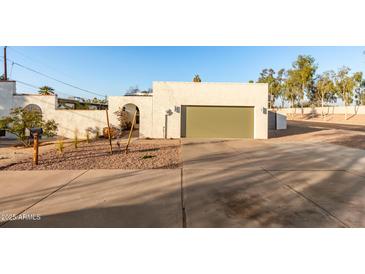 Front view of a single-story home with a green garage door and desert landscaping at 2916 S Price Rd, Tempe, AZ 85282