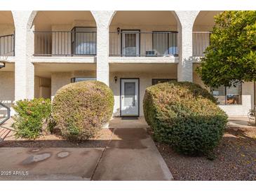 Exterior view of condo building with unit entrance and landscaping at 3270 S Goldfield Rd # 203, Apache Junction, AZ 85119