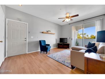 Bright living room with wood floors, comfy seating, and sliding door to balcony at 3302 N 7Th St # 366, Phoenix, AZ 85014