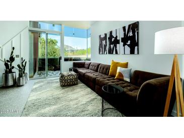 Open living space with sectional sofa, access to patio, and city views at 3707 N Marshall Way # 3, Scottsdale, AZ 85251