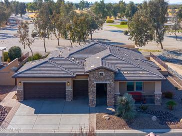 Single-story home with a tile roof, two-car garage, and desert landscaping at 4557 W Agave Ave, Eloy, AZ 85131